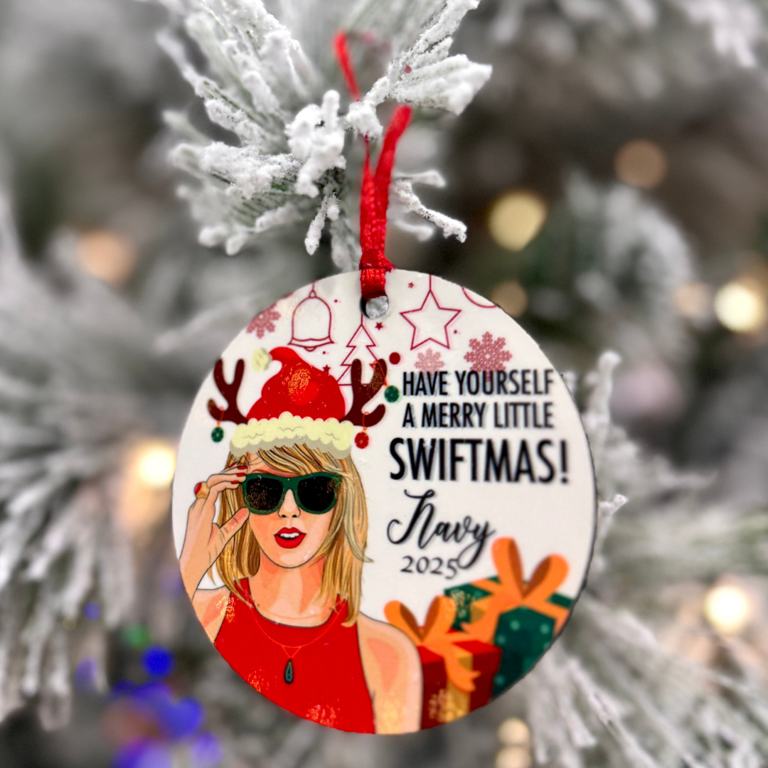 Personalized Swiftmas ornament hanging on a frosted Christmas tree, perfect for music lovers and holiday decor.